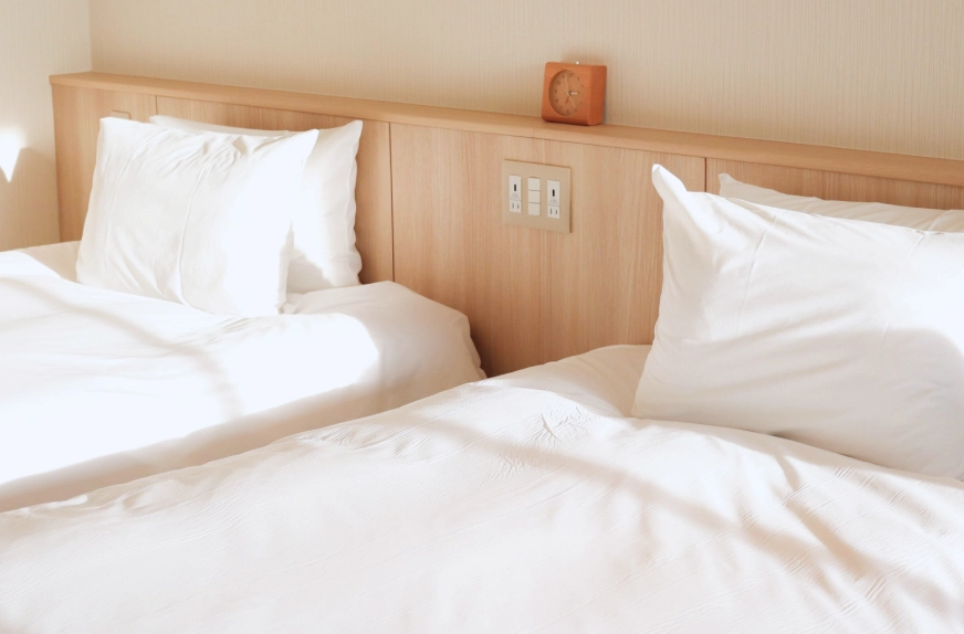 整えられた寝室。真っ白なベッドが二つ並んでいる様子。